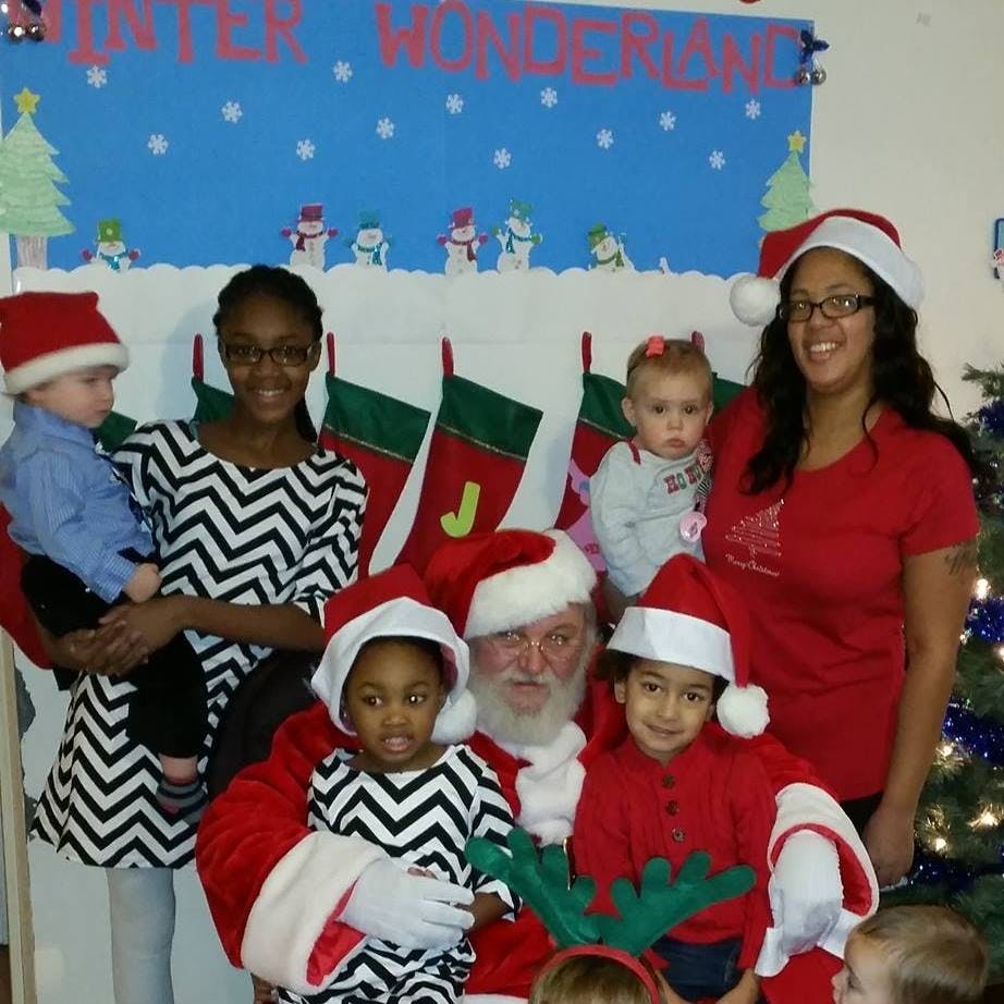 People and children posing with Santa Claus