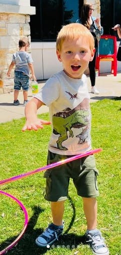 Child playing with a hula hoop outdoors