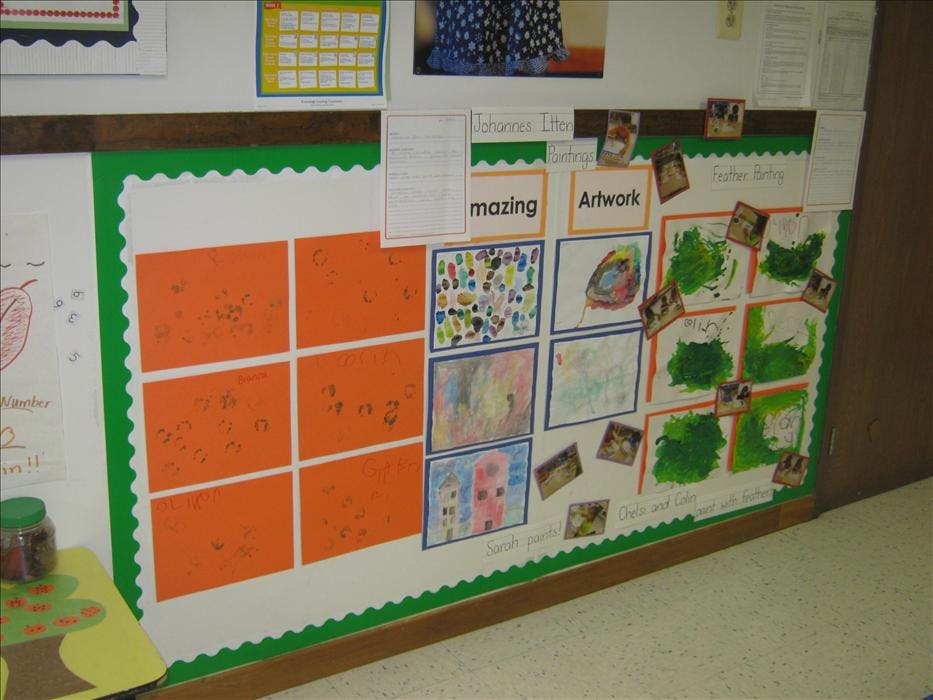 Classroom bulletin board with various children's artwork and text