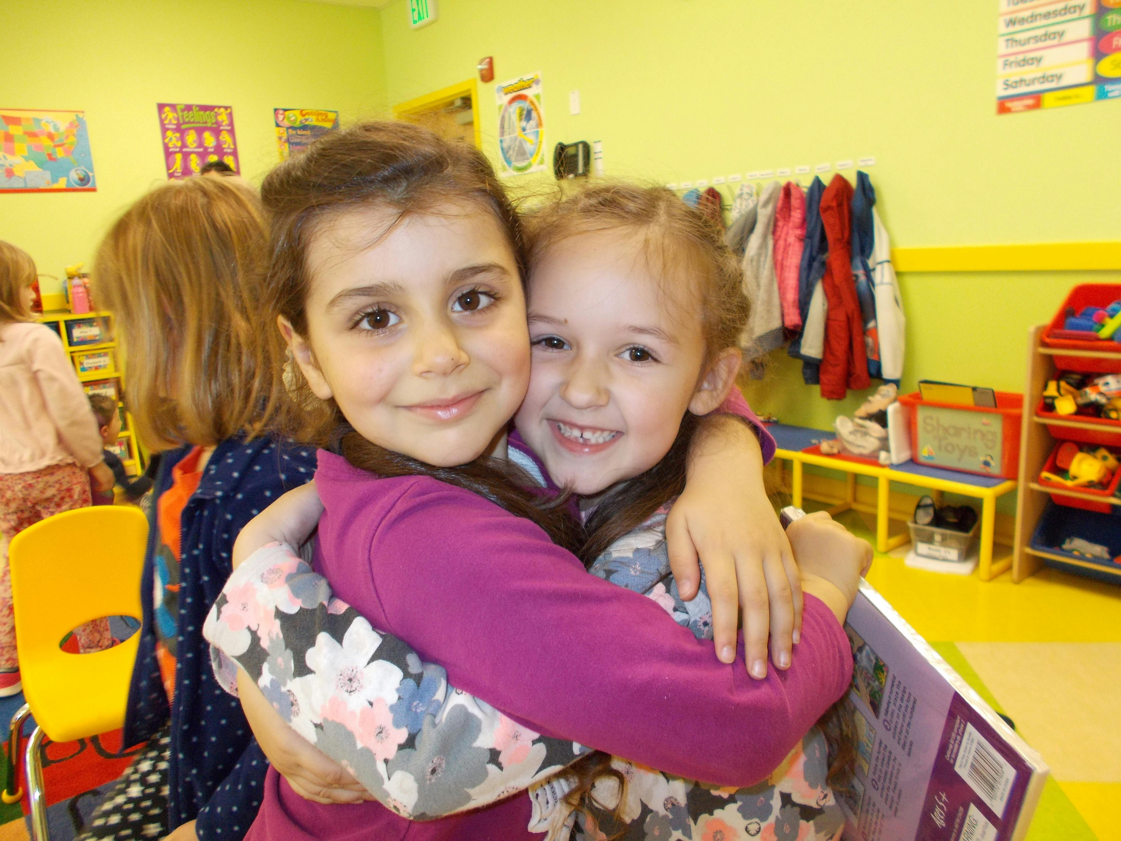 Two children hugging in a classroom