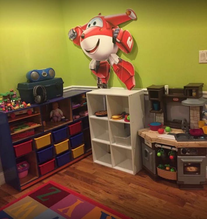 Playroom with toy storage, play kitchen, and large cartoon airplane cutout