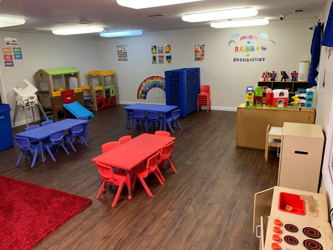 Empty classroom with small red and blue tables and chairs
