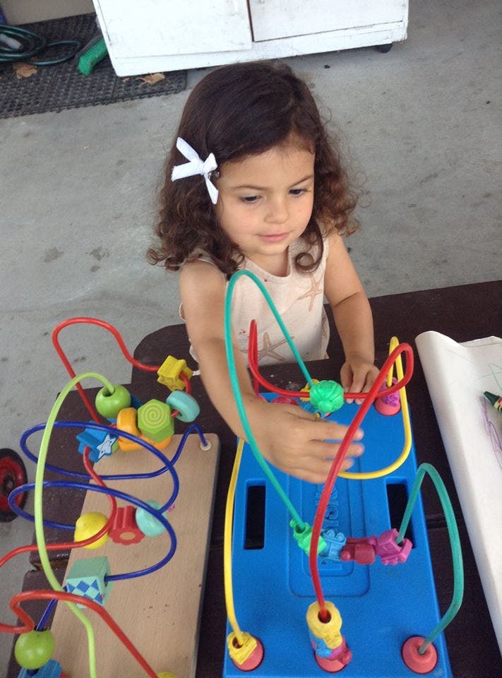 Child playing with a bead maze toy