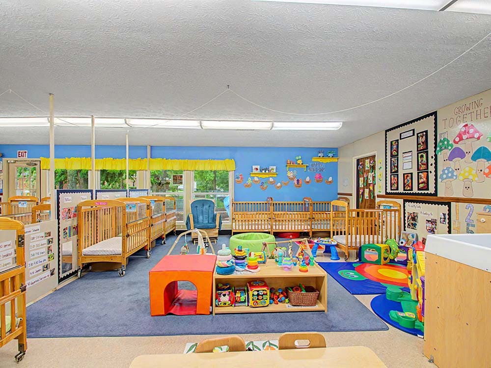 A colorful room with many cribs, toys, and decorations