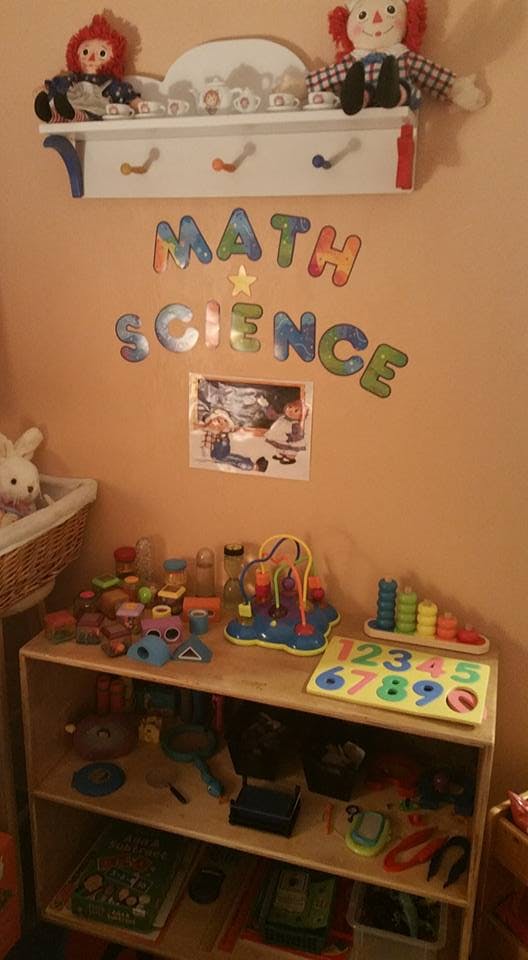 Children's room with toys, a bookshelf, and "MATH SCIENCE" on the wall