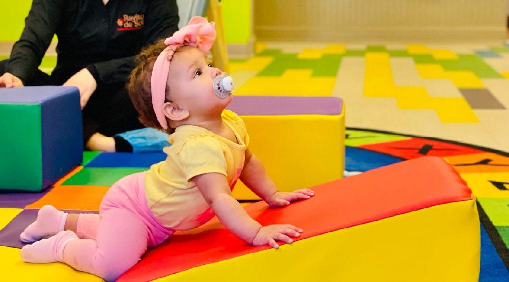 Child crawling on soft play equipment in a classroom