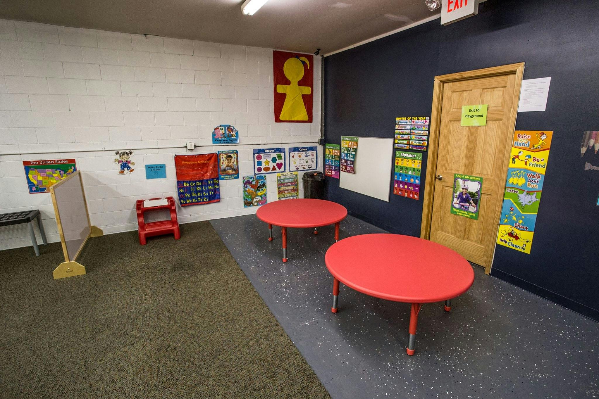 Classroom with red tables and educational posters on the walls
