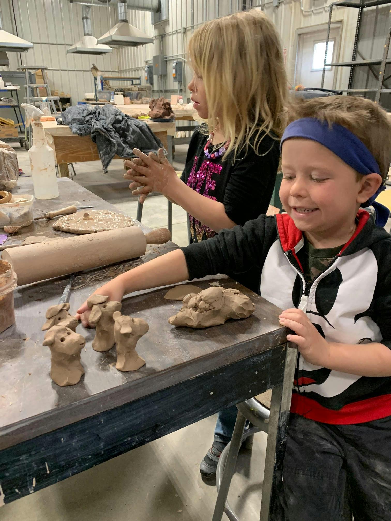 Two children working with clay at a table