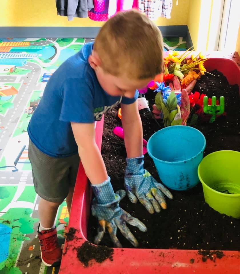 Child wearing gloves playing in dirt