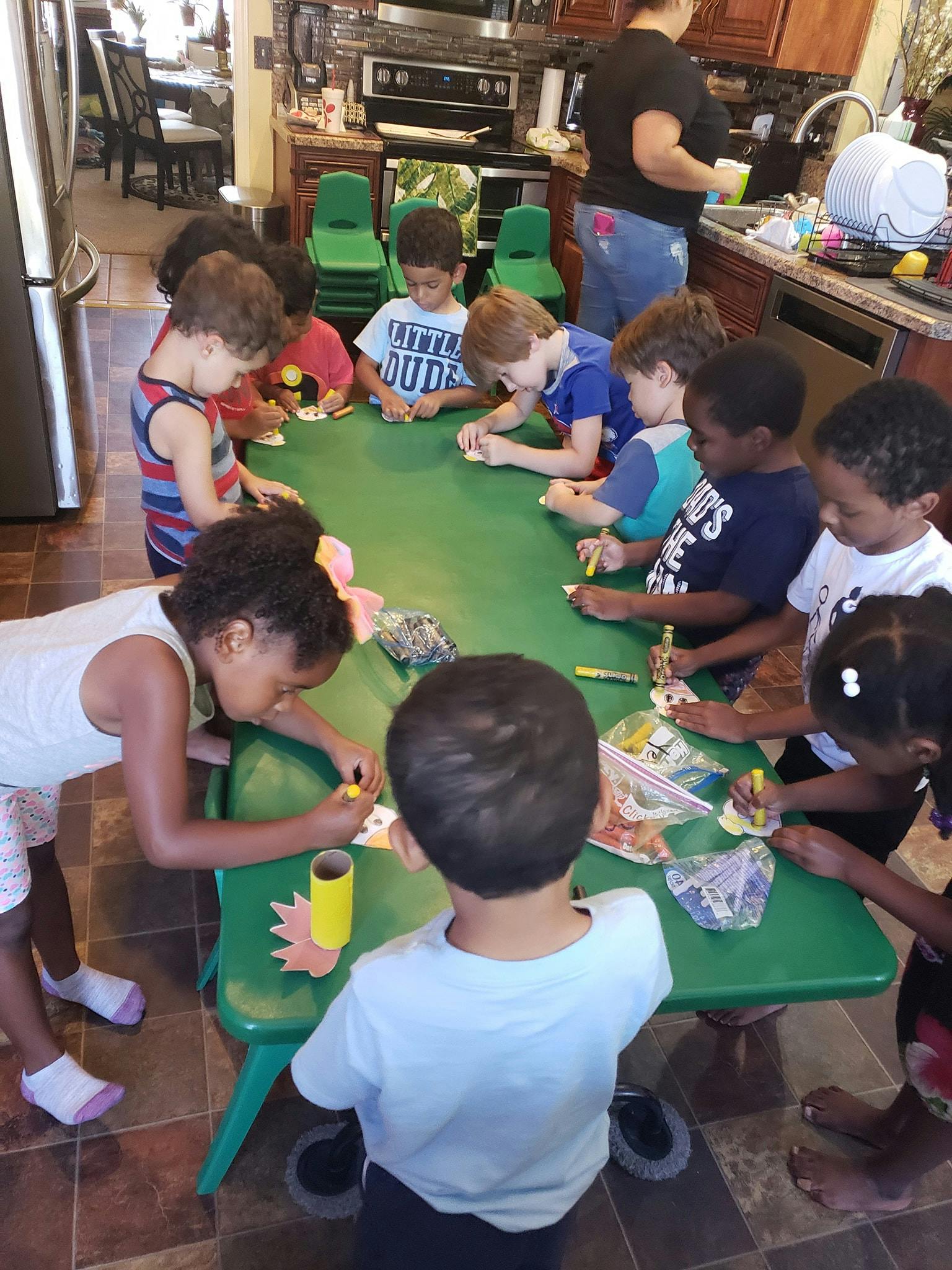 Children gathered around a table doing crafts