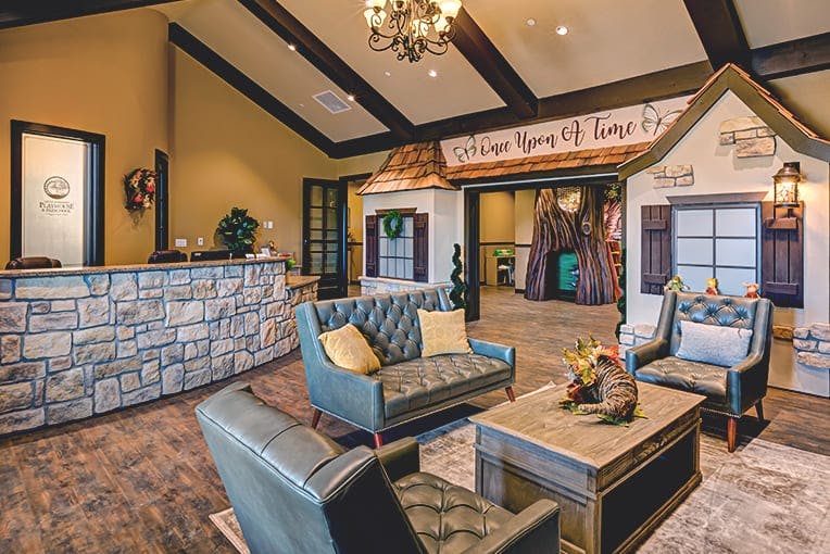 Lobby with stone reception desk, seating area, and playhouse structures