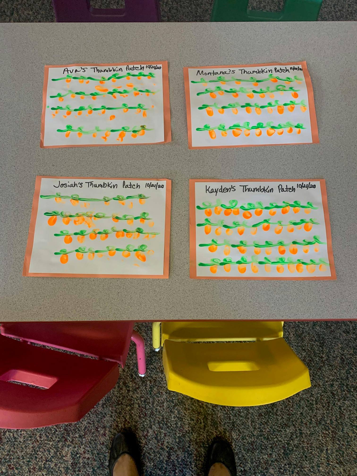 Four children's pumpkin patch art projects on a table