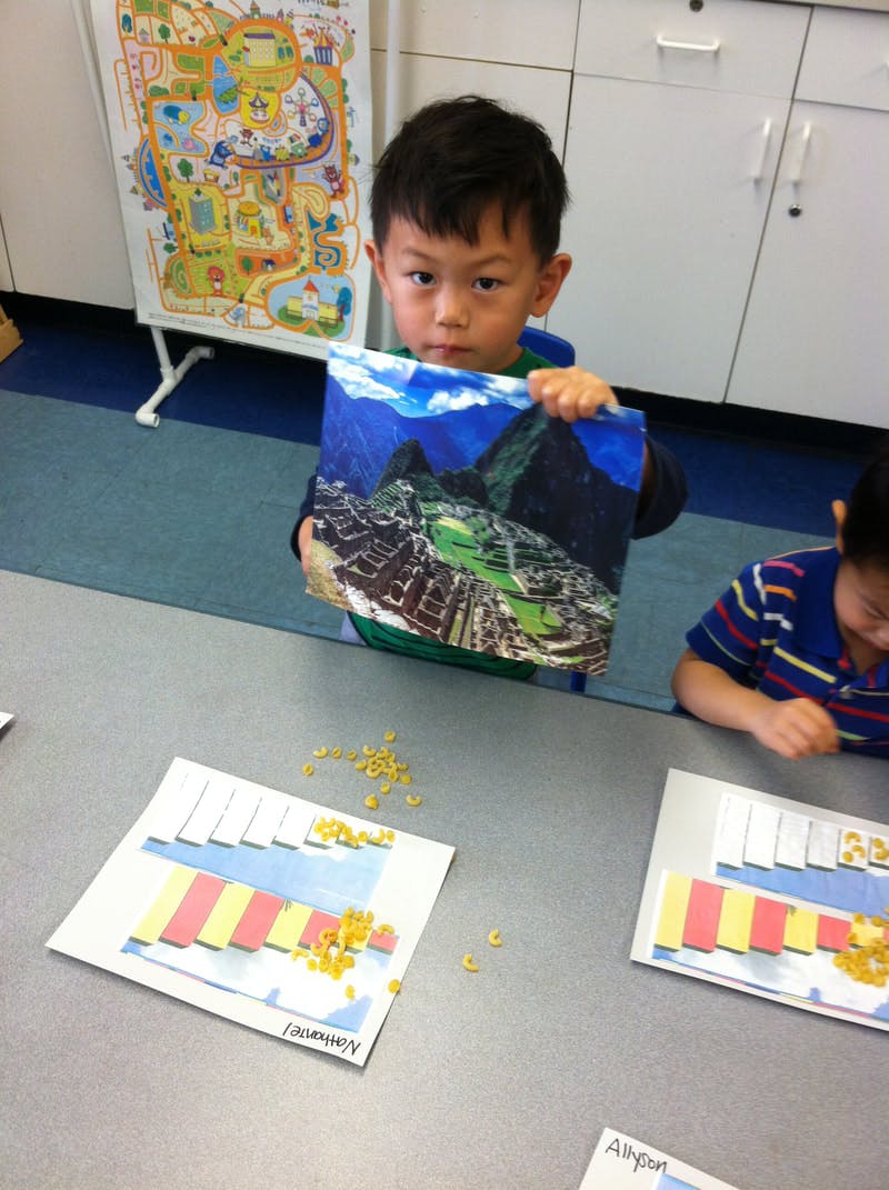 Child holding up a picture of a mountain landscape