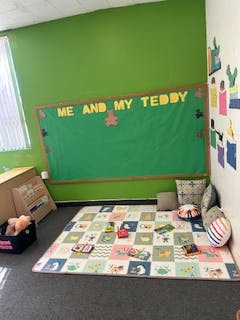 Classroom with a green bulletin board that says "ME AND MY TEDDY"