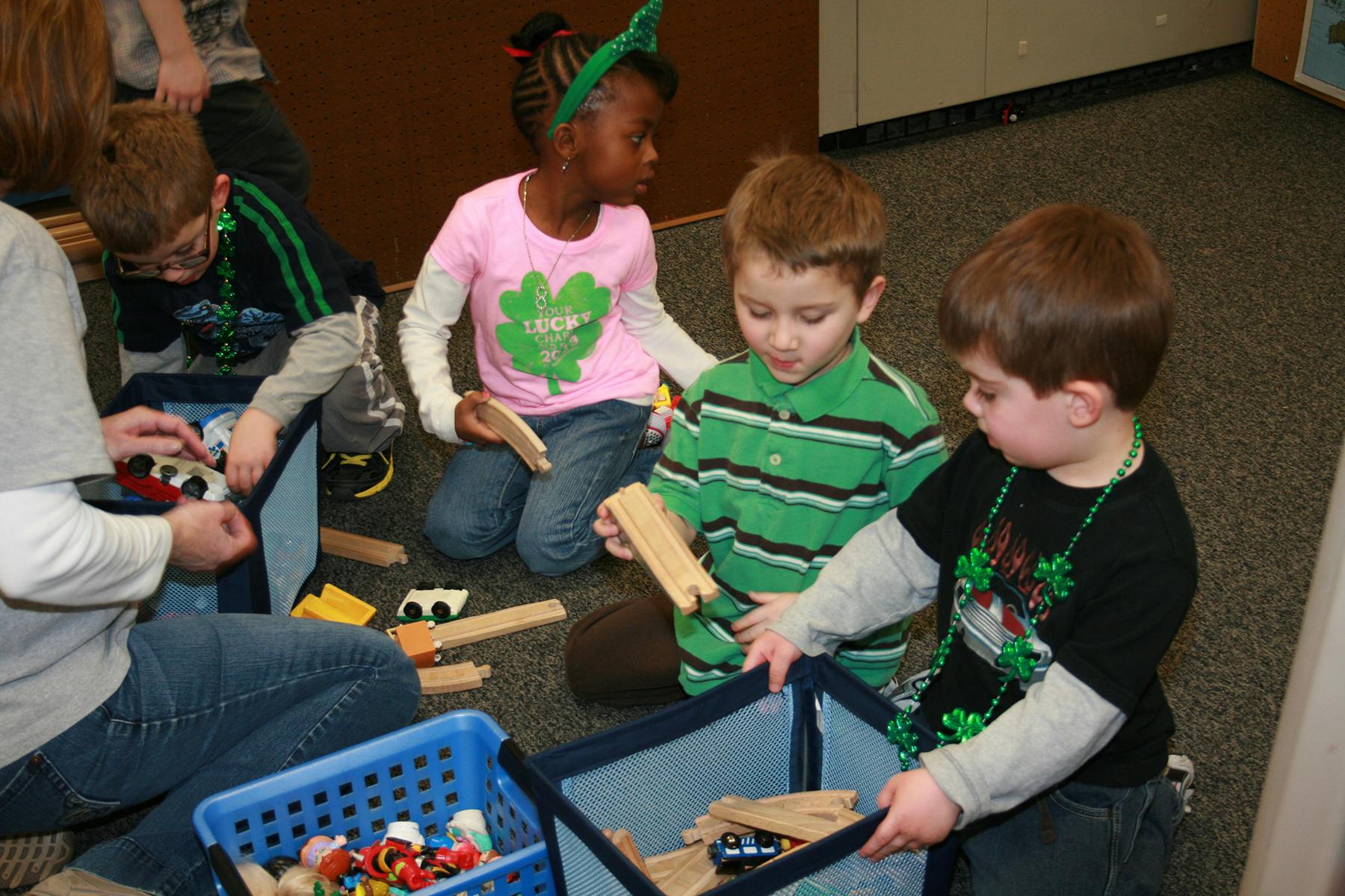 Children playing with wooden blocks and toys on the floor
