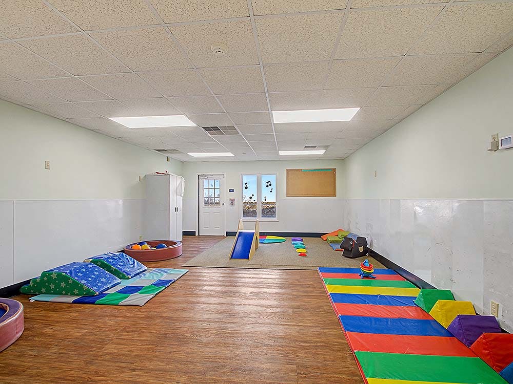 Child's play room with soft play equipment, slides, and colorful mats