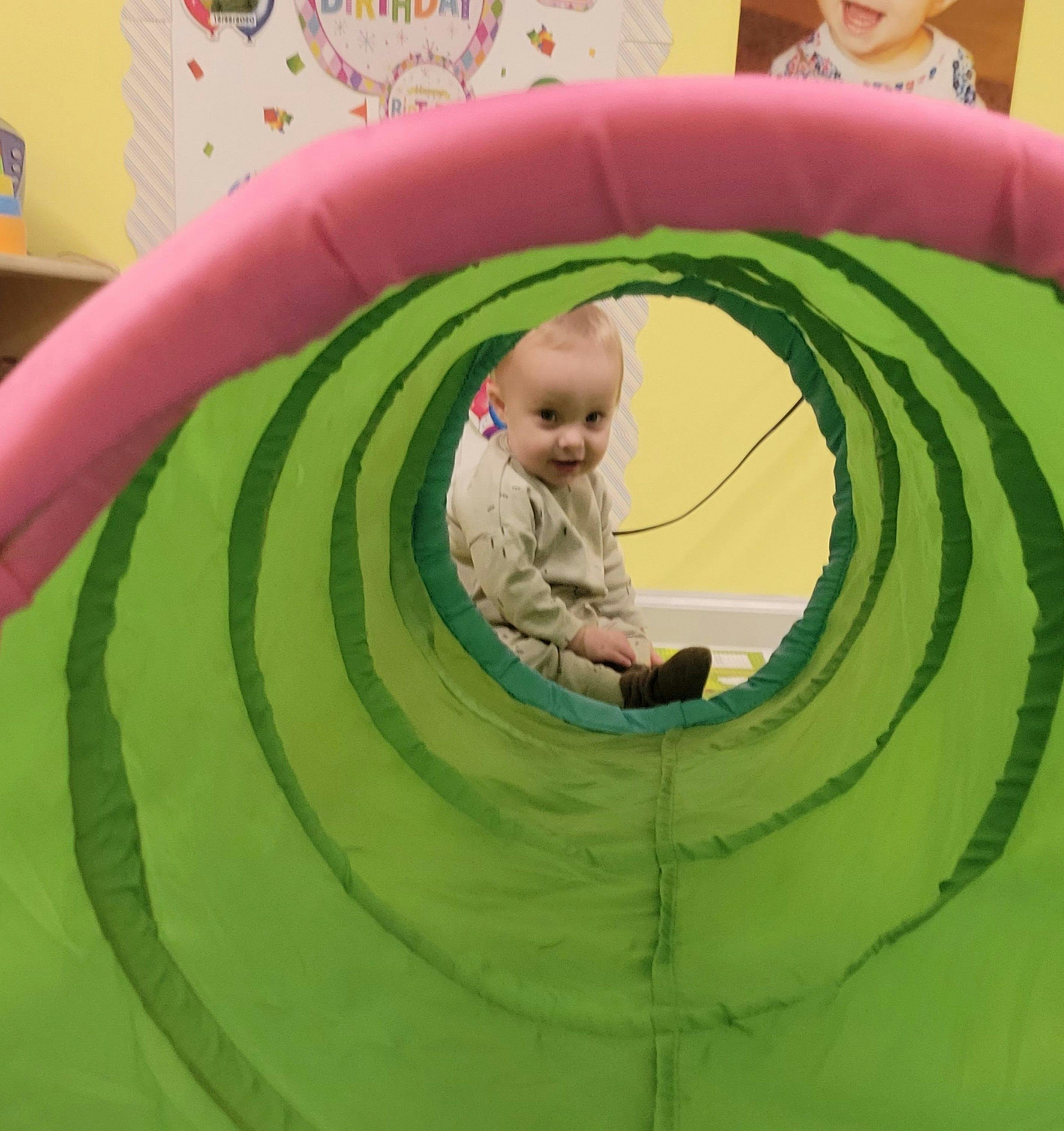 Child sitting inside a play tunnel