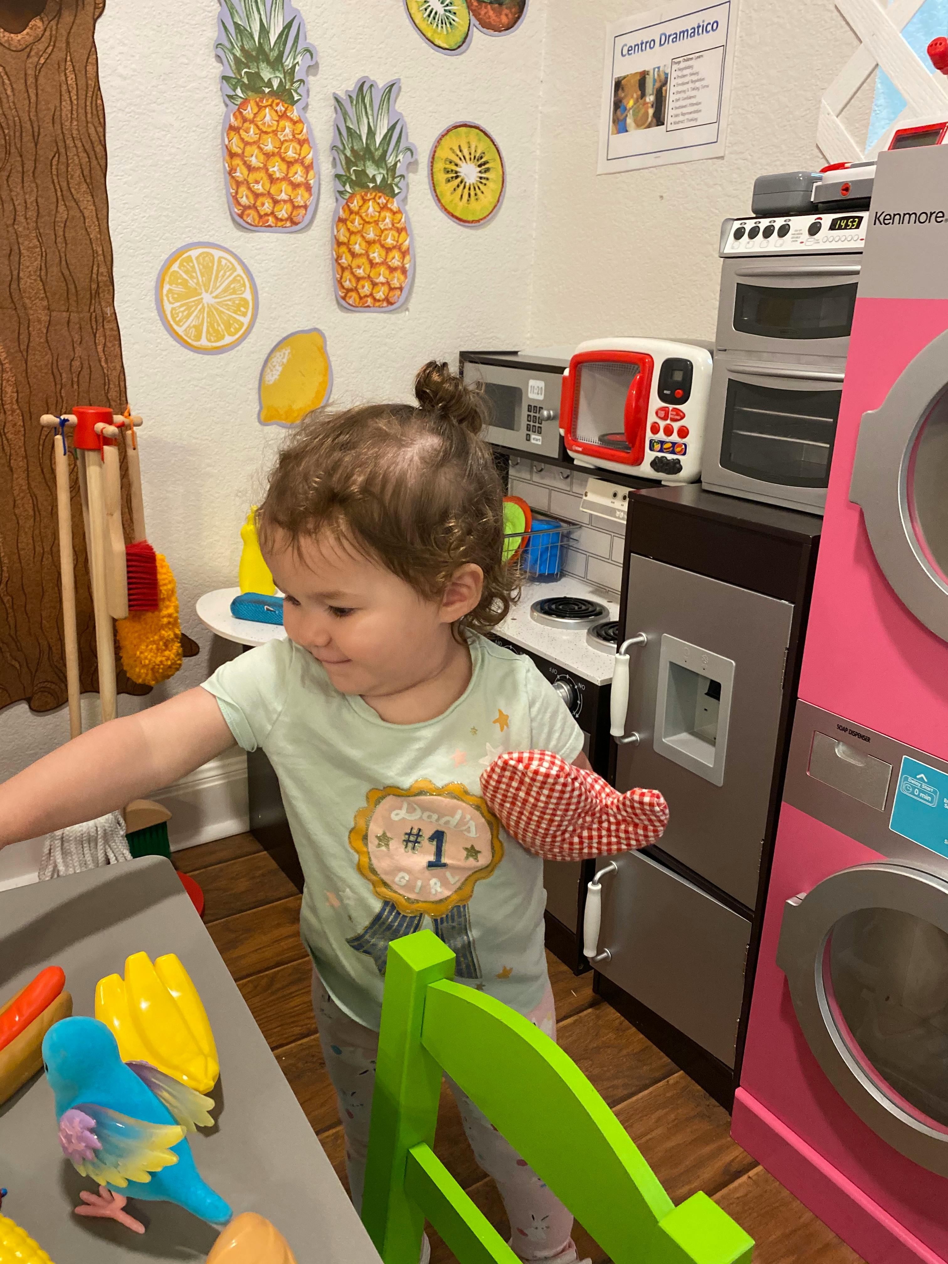 Child playing in a toy kitchen