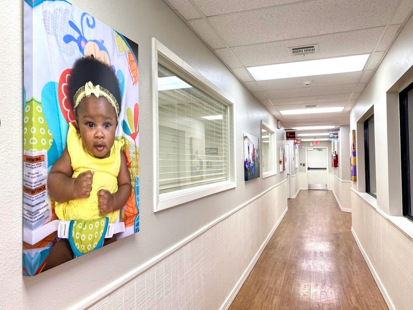 Hallway featuring a large portrait of a child on the wall