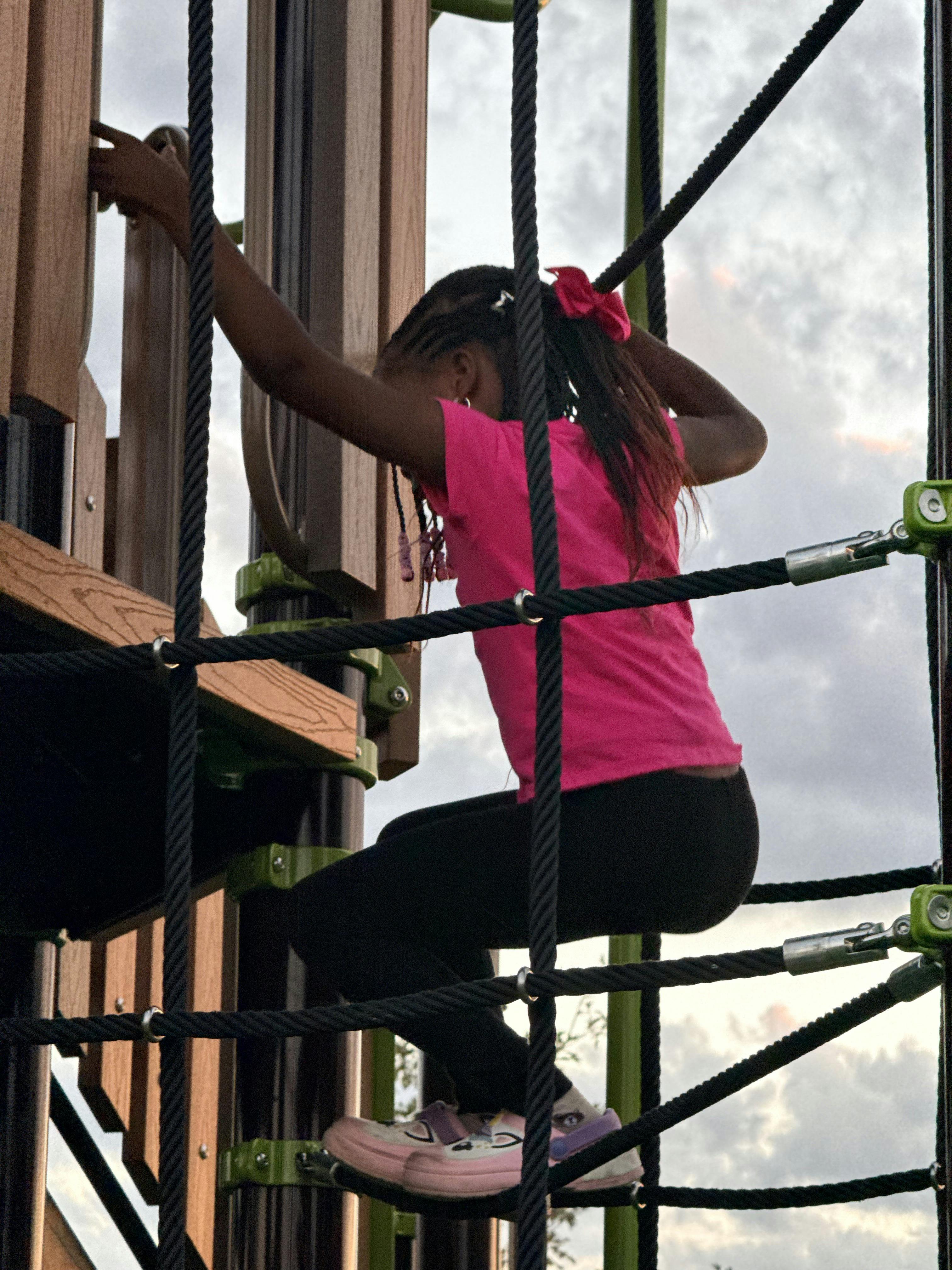 Child climbing on a rope playground structure