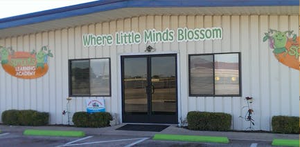 Building exterior with text "Where Little Minds Blossom" above double doors