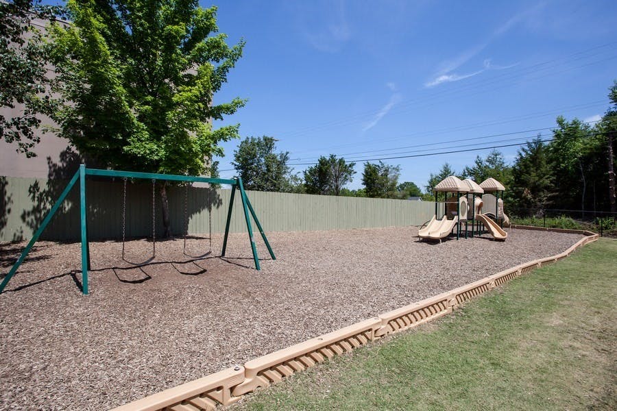 Outdoor playground with swings and a slide structure with slide structure