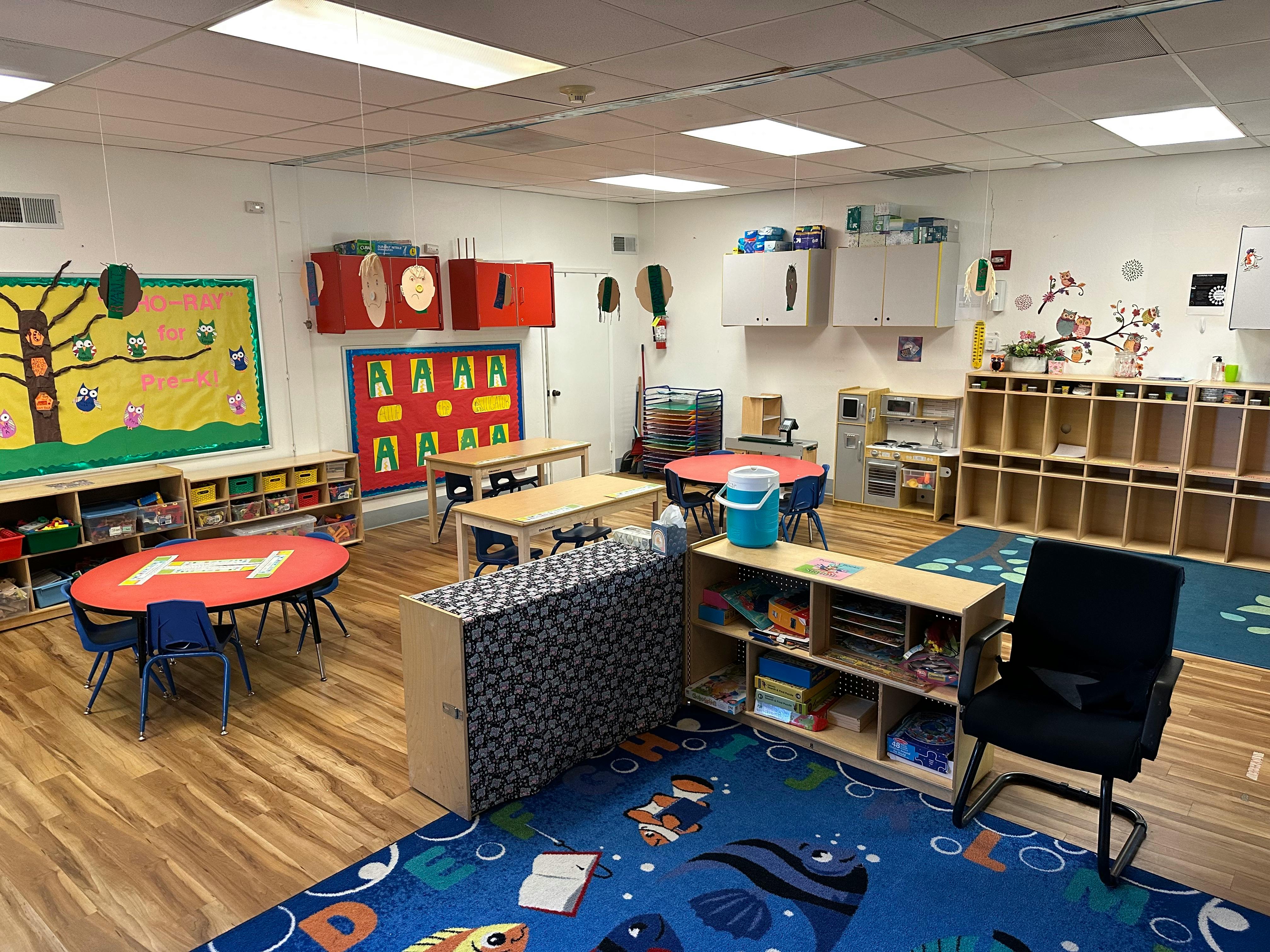 Empty classroom with tables, chairs, and storage shelves