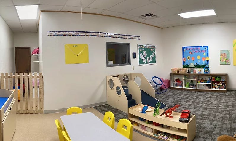 Playroom with small table and chairs, slide, and toy shelves