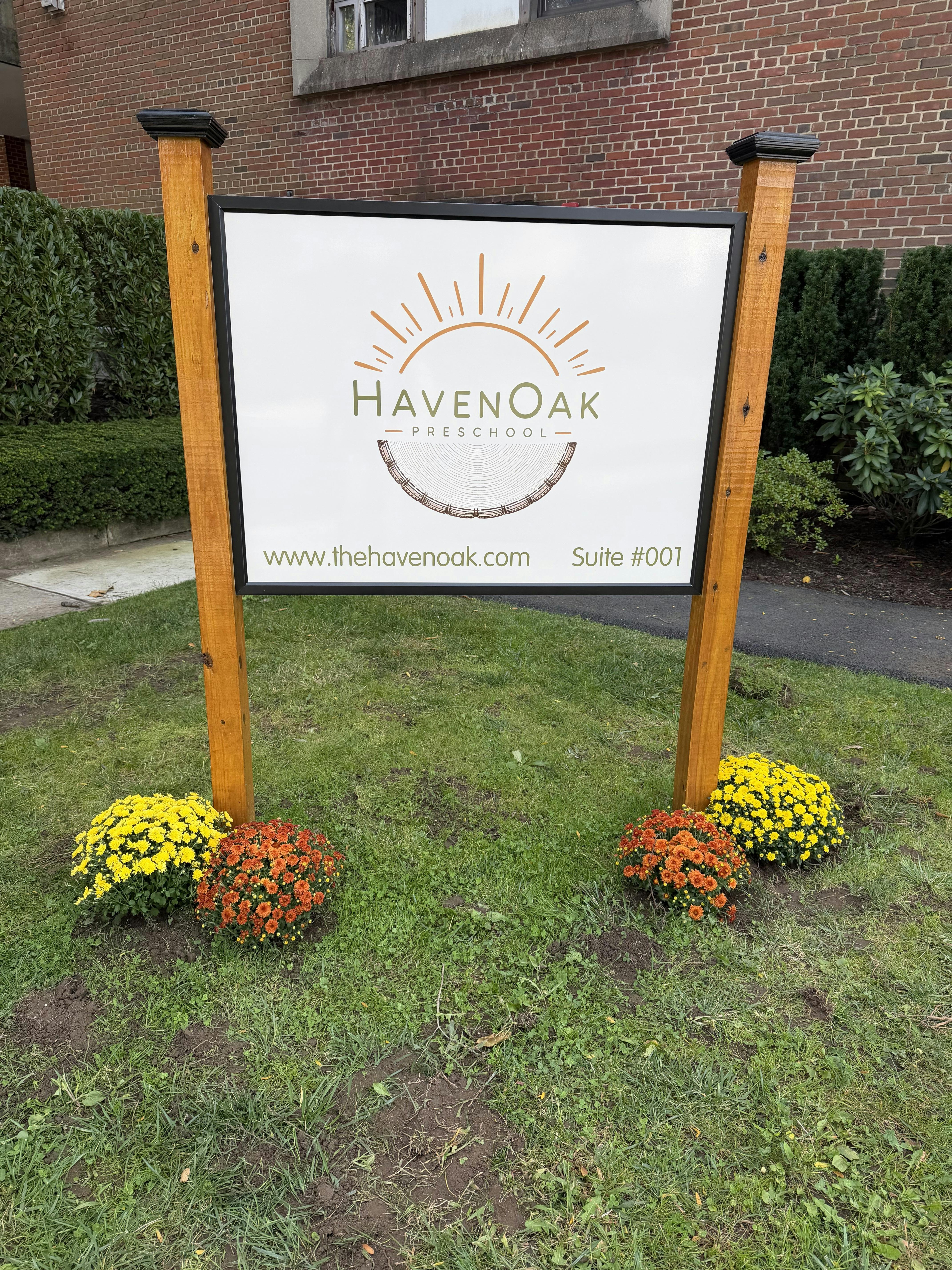 Sign for HavenOak Preschool with website and suite number on a lawn