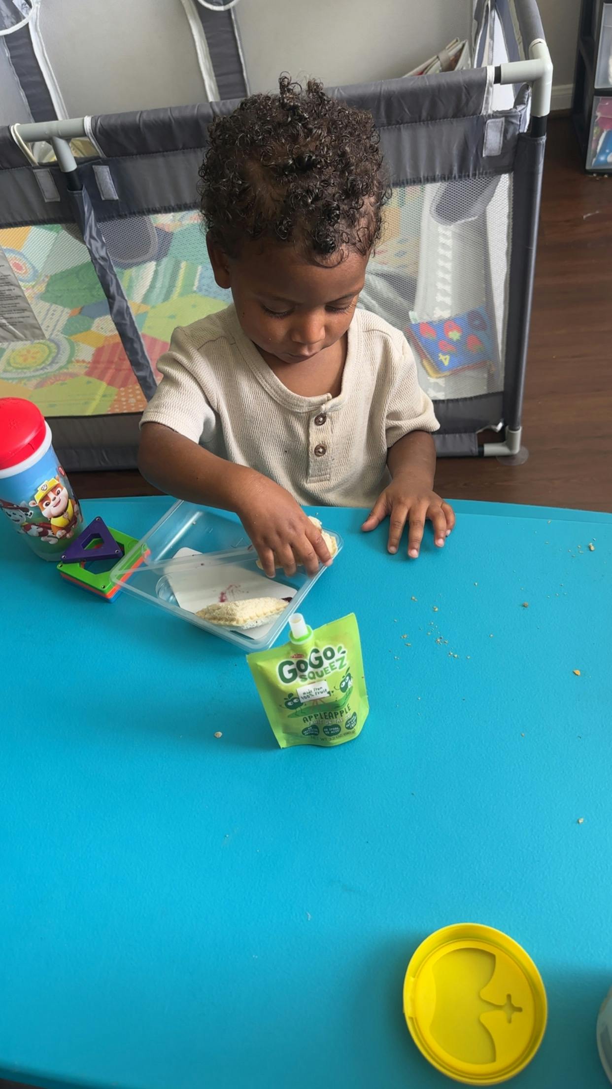 Child playing with food on a blue table