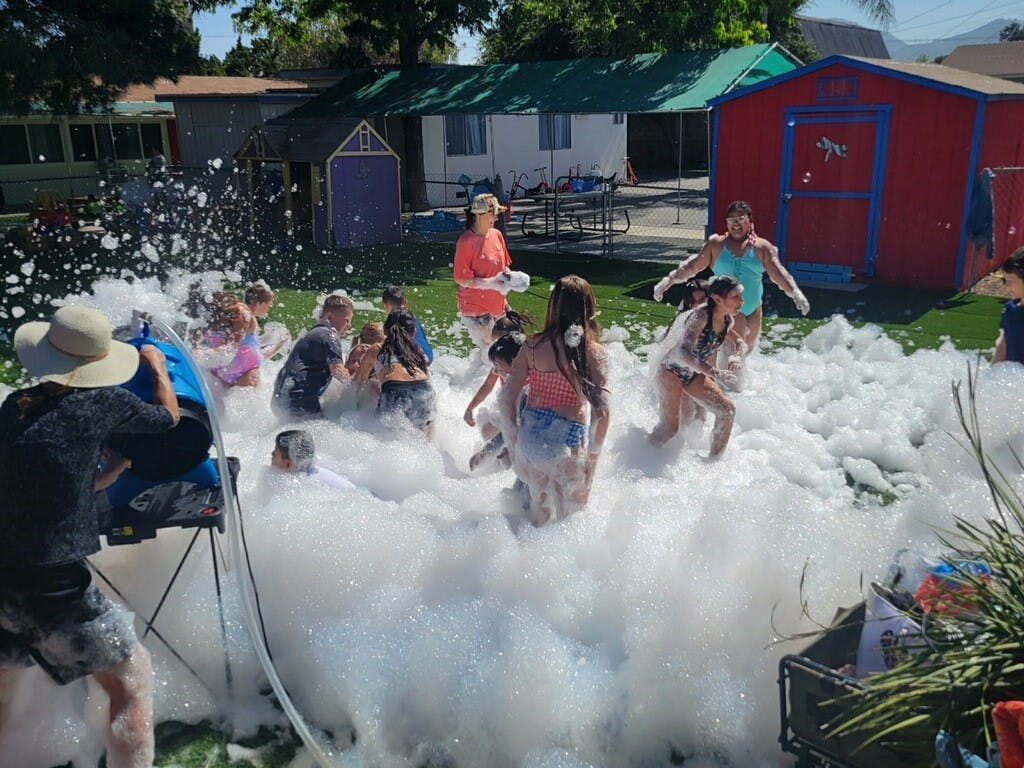 People playing in a large pile of foam outdoors