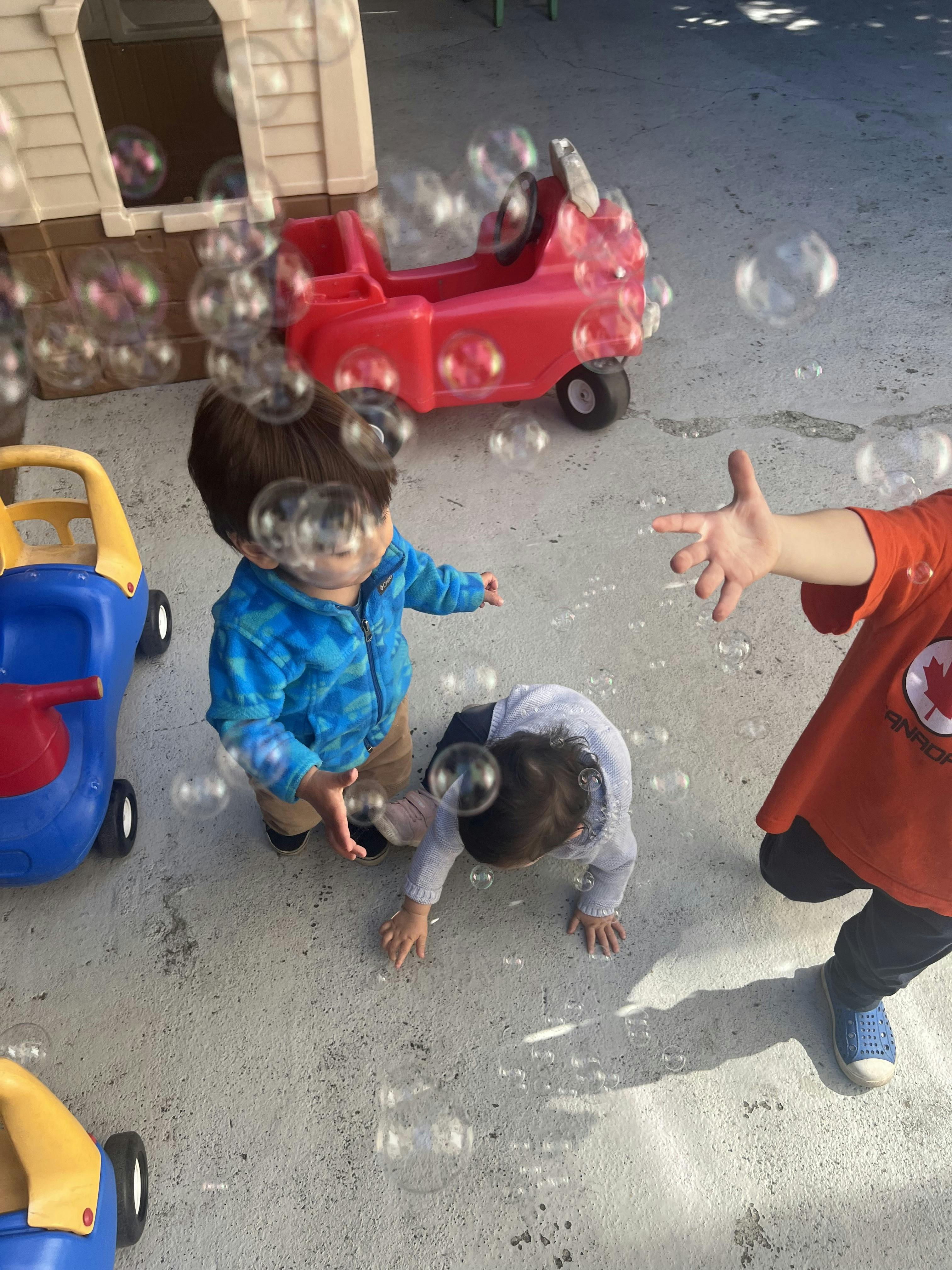 Children playing with bubbles outdoors