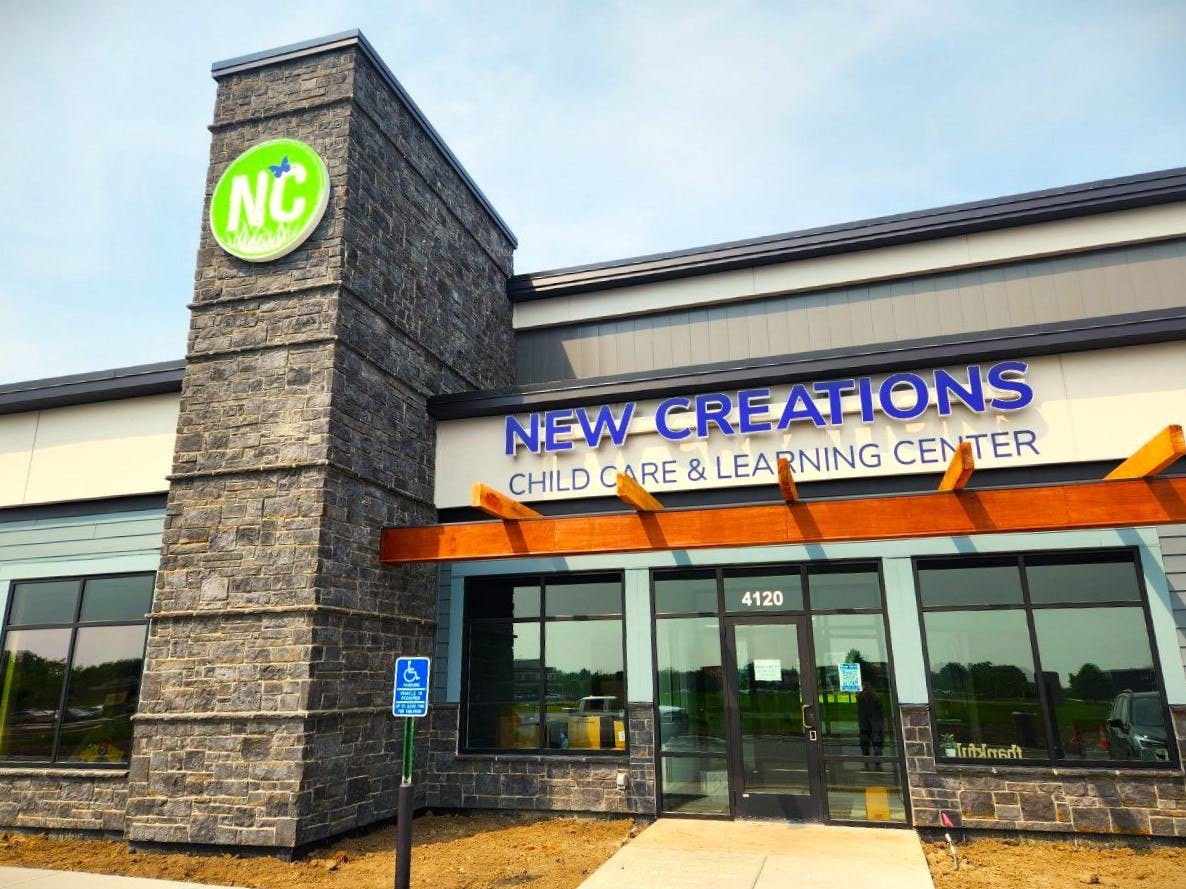 Building exterior with "New Creations Child Care & Learning Center" sign