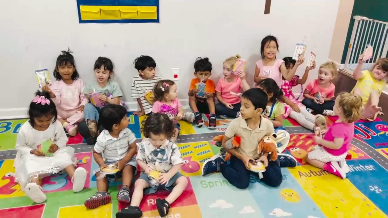 Group of children sitting on a colorful floor rug in a classroom