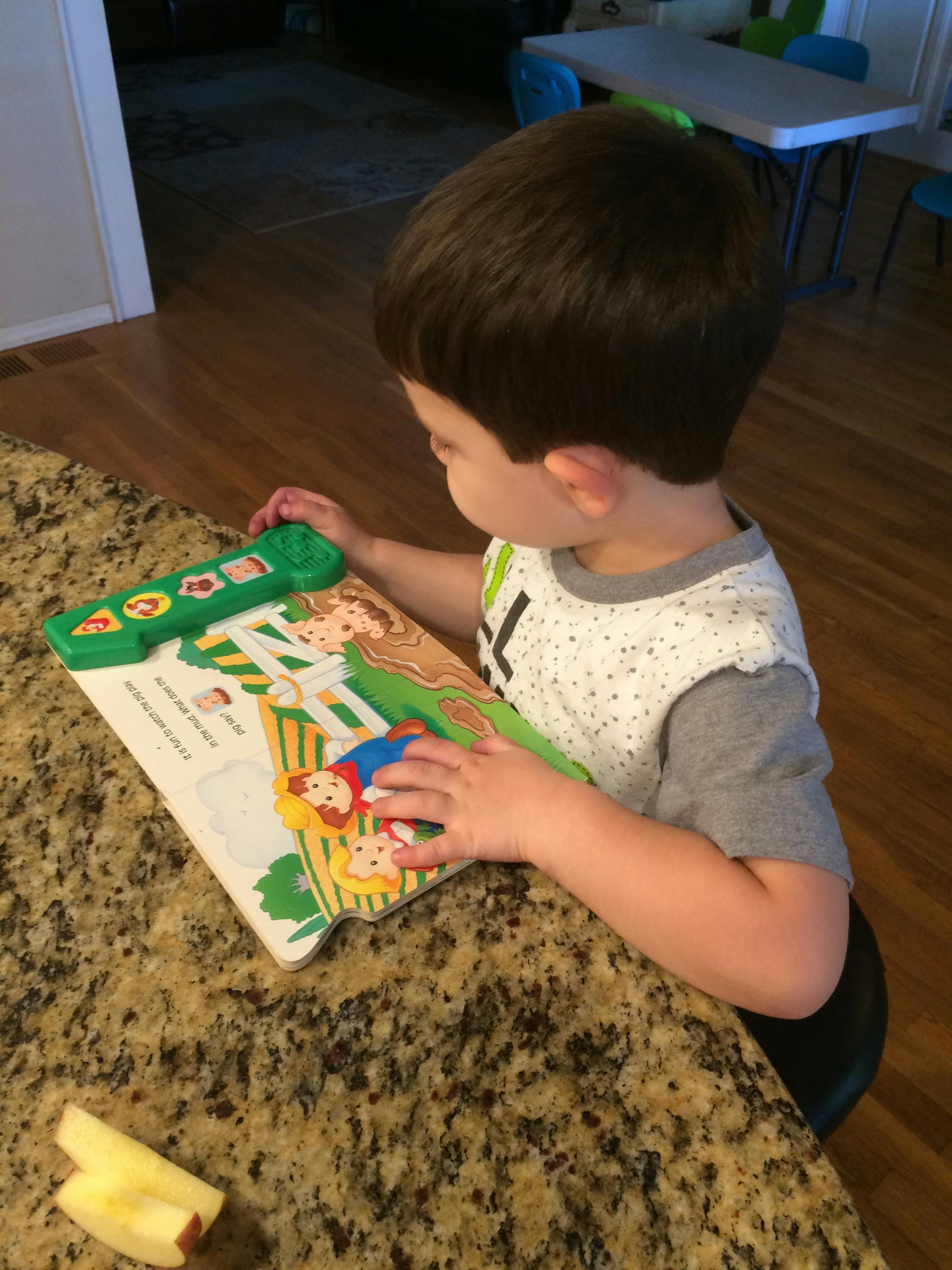Child looking at an open book with illustrations