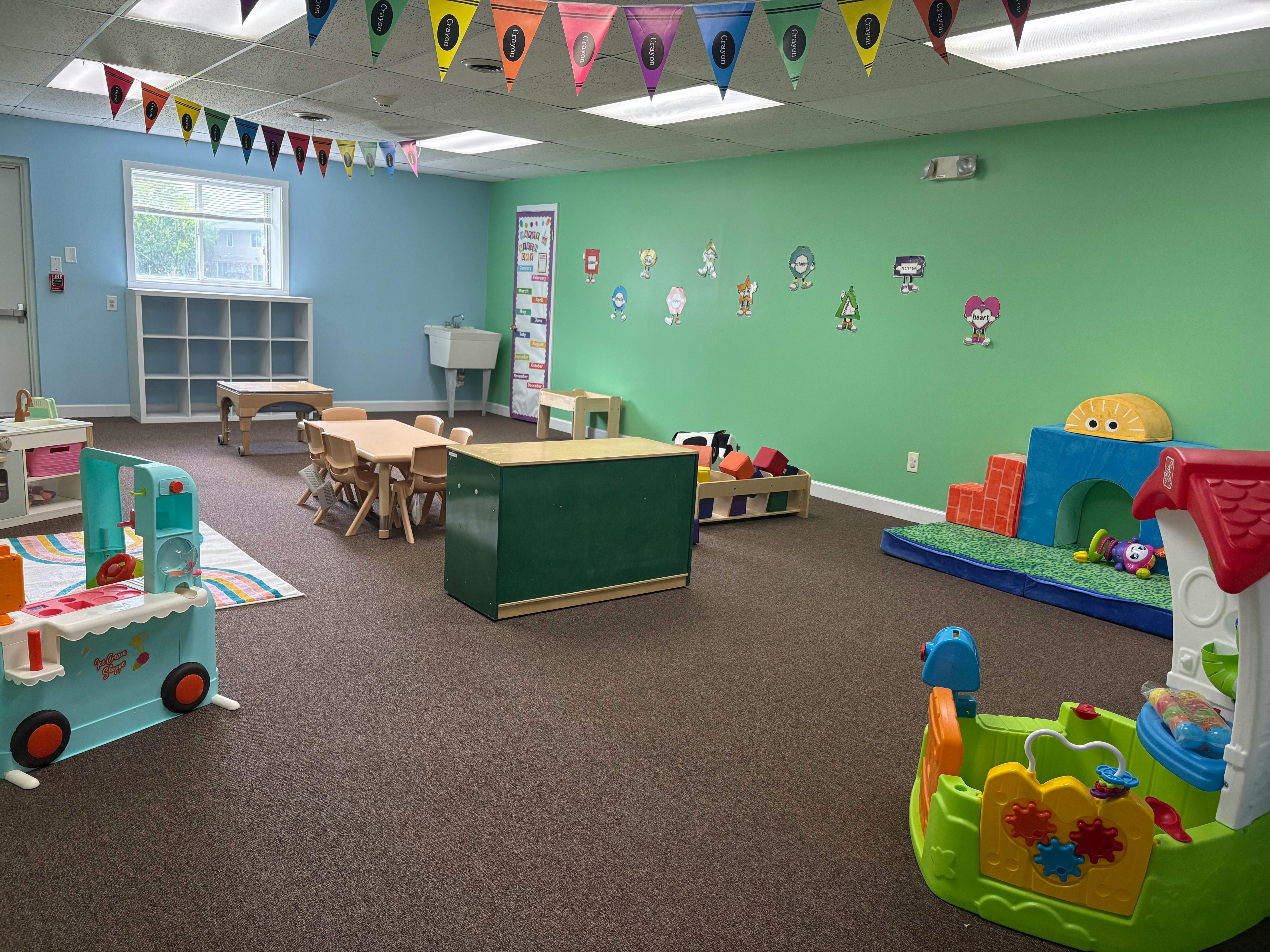 Playroom with small tables, chairs, and colorful play equipment