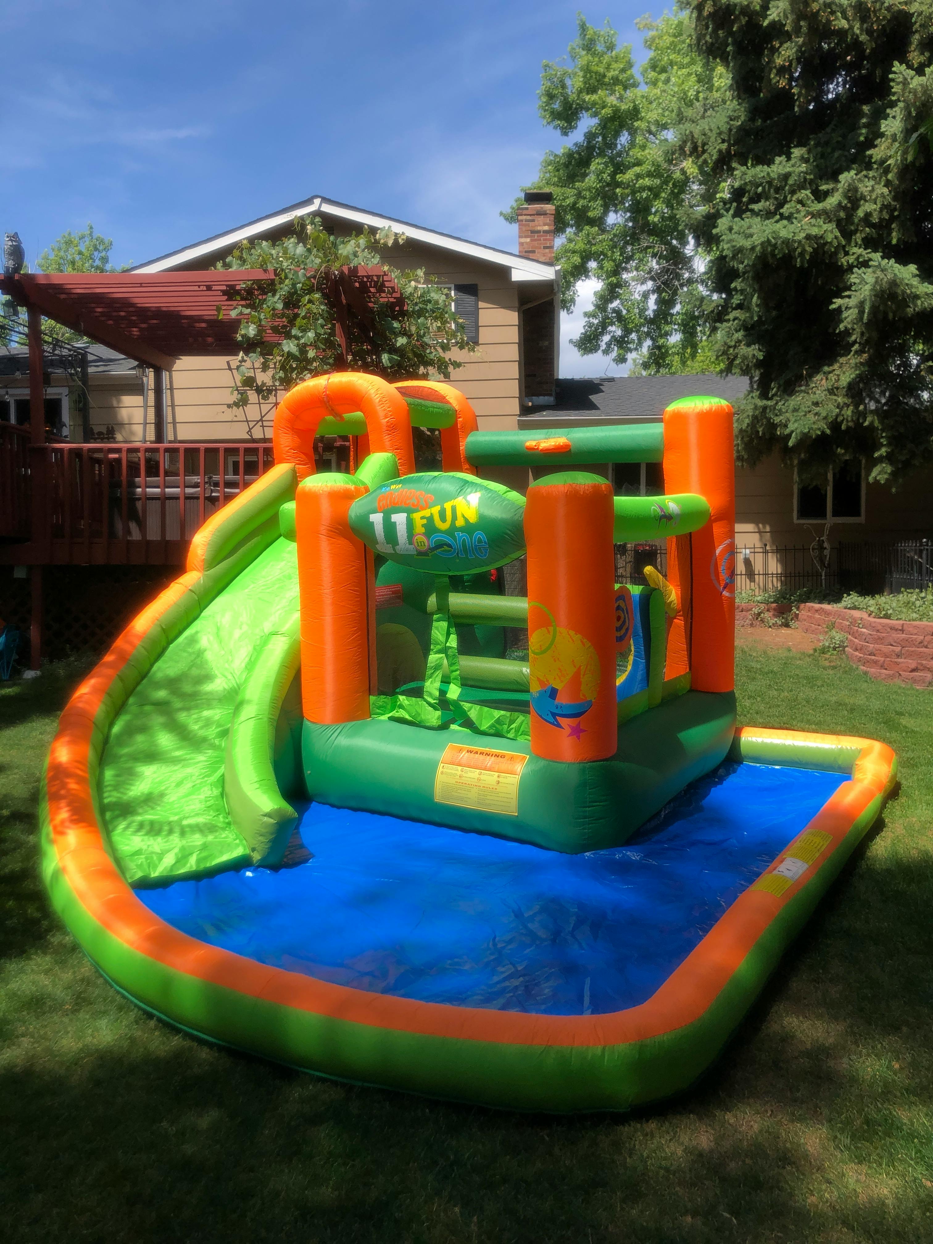 Inflatable bounce house with a slide and water pool