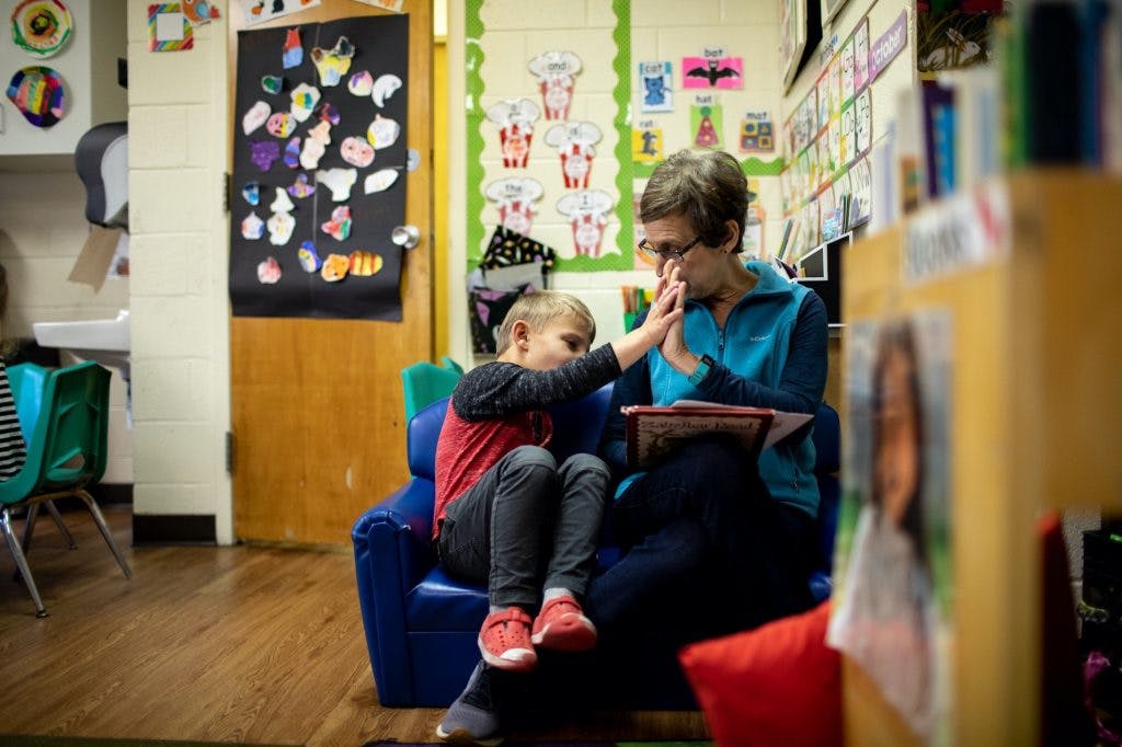 Adult and child sitting together, child touching adult's face