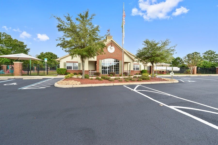 Building with a brick facade and a flagpole in front of a parking lot