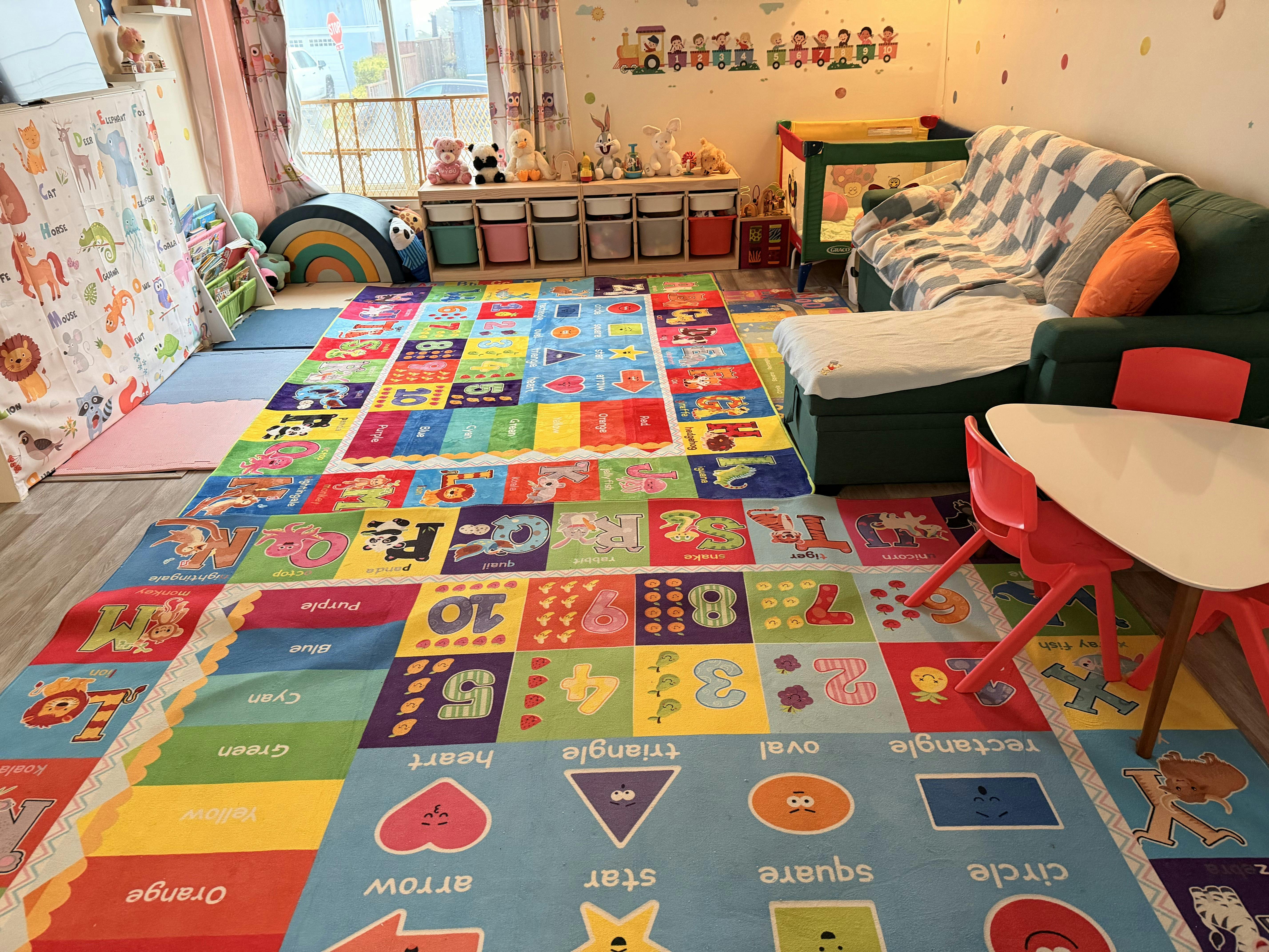 Colorful educational rug with letters, numbers, and shapes in a playroom with toys and furniture