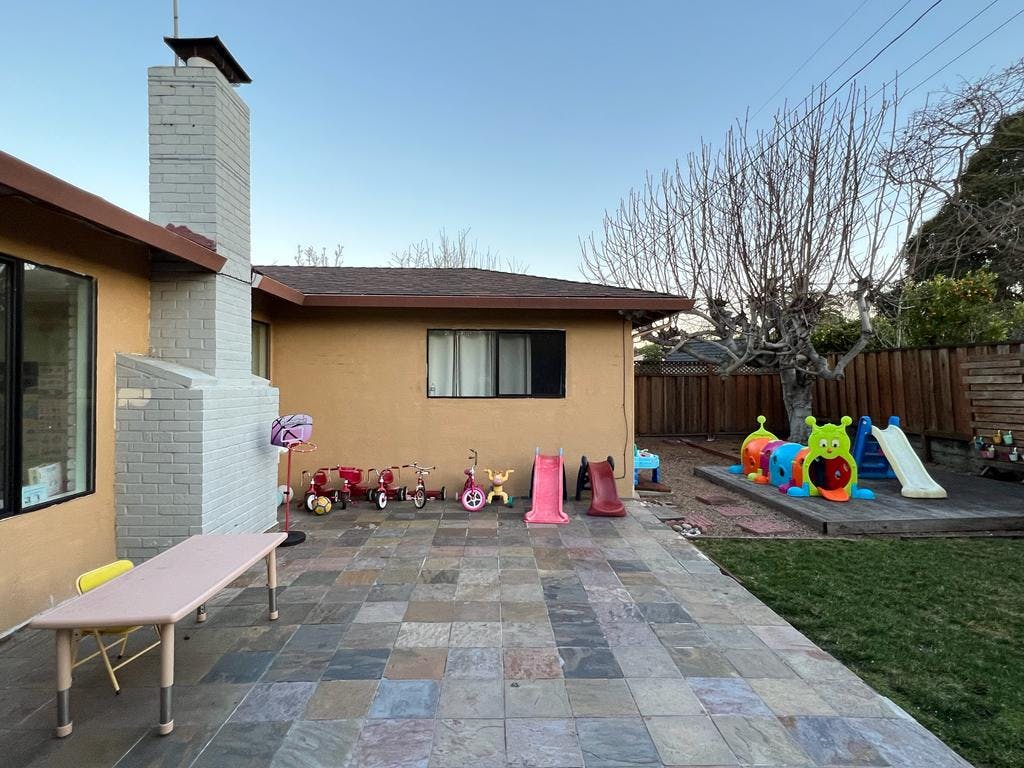 Backyard patio with children's toys and play equipment