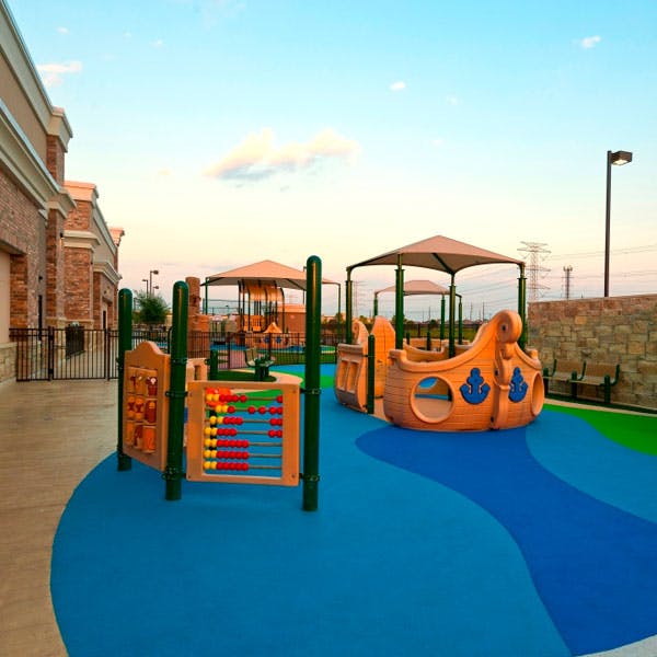 Playground with abacus and boat-shaped play structure on blue and green ground