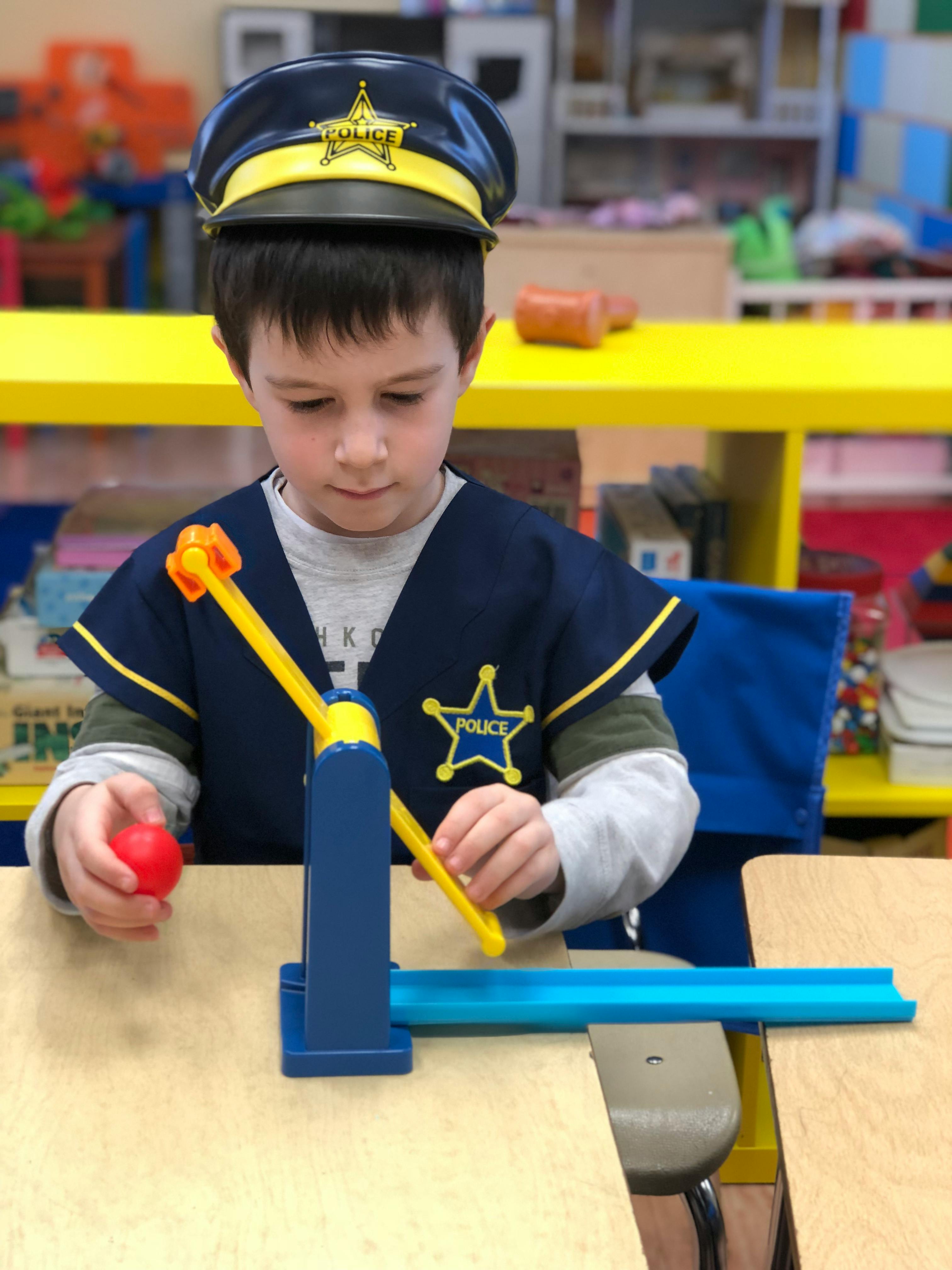 Child in police hat and vest playing with a toy