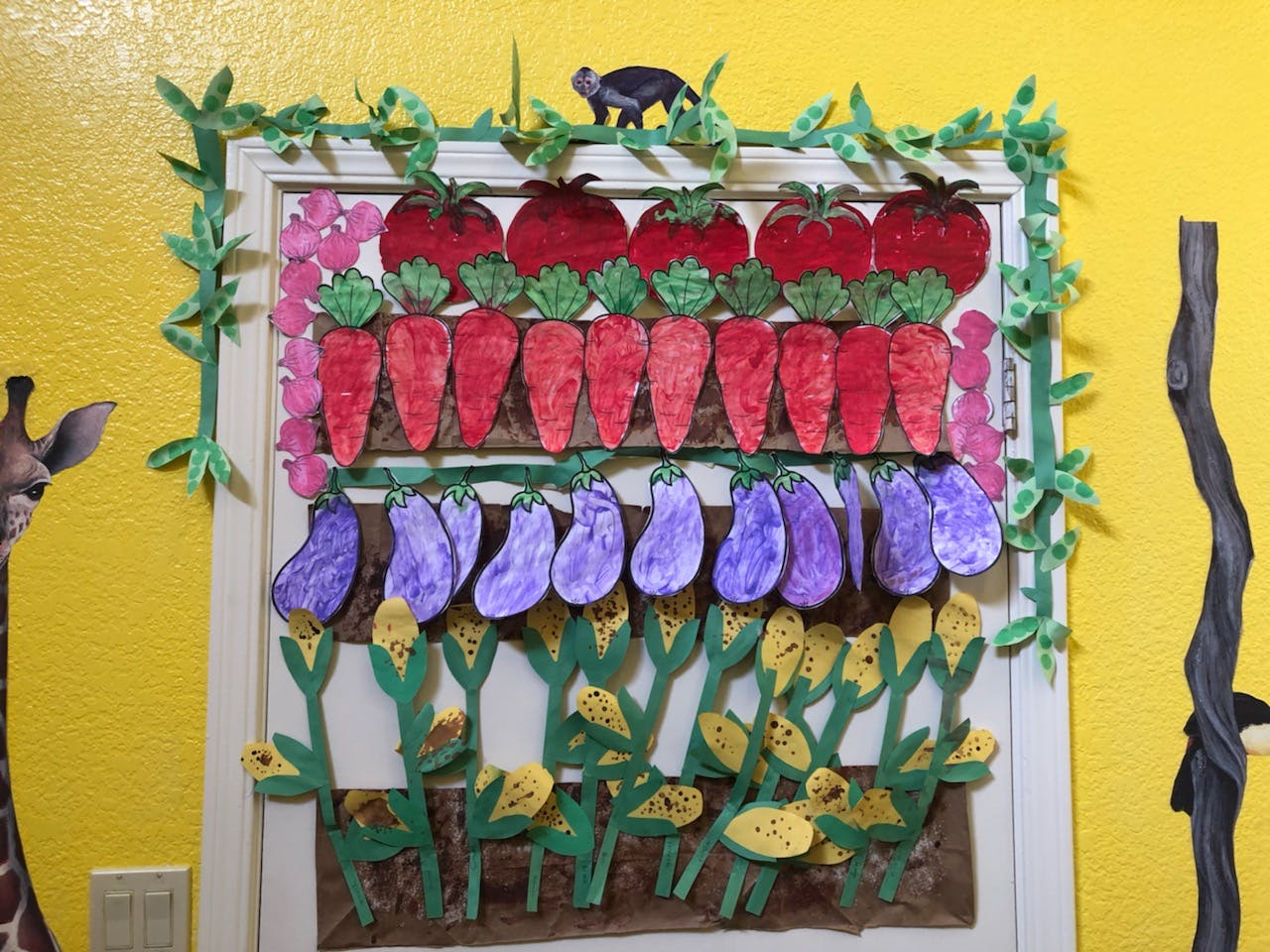 Craft display of tomatoes, carrots, eggplants, and corn