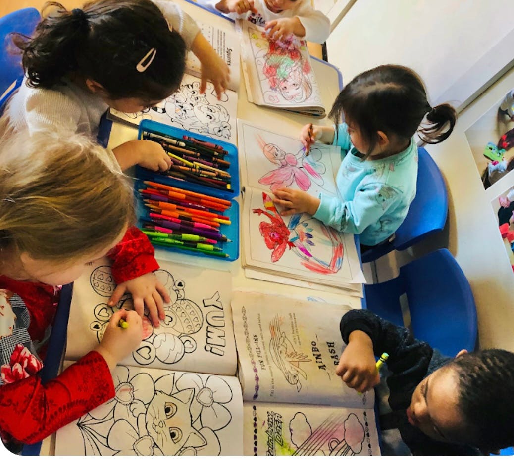 Children coloring in books at a table