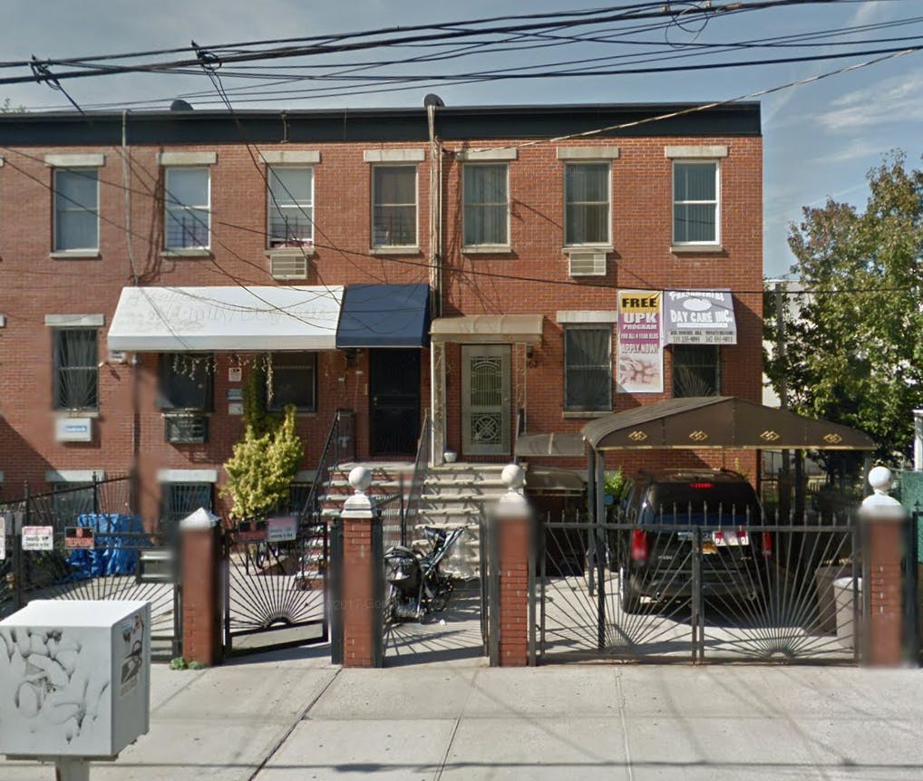 Brick apartment building with awnings and a gated driveway
