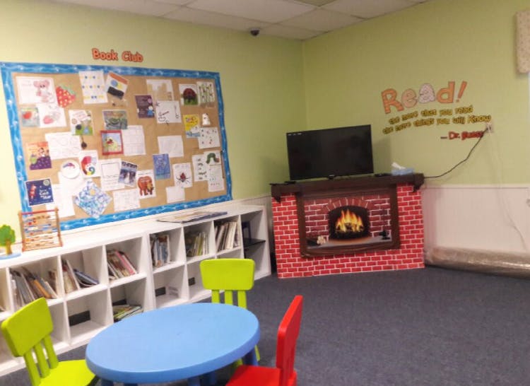 Children's reading nook with a bulletin board, bookshelves, and small table