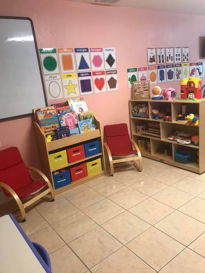 Classroom with a whiteboard, book display, and shelves with toys