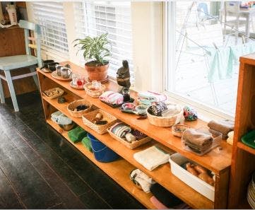 Shelves with various items, baskets, and a potted plant near a window
