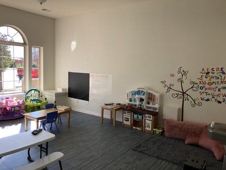 Playroom with tables, chairs, and toys